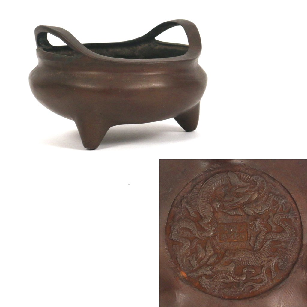 CHINESE BRONZE TRIPOD CENSER: with double handles, the bottom with a medallion of two dragons and a Xuande (1426-1435) reign marks, h. 4 1/2 d. 6 1/2 in.