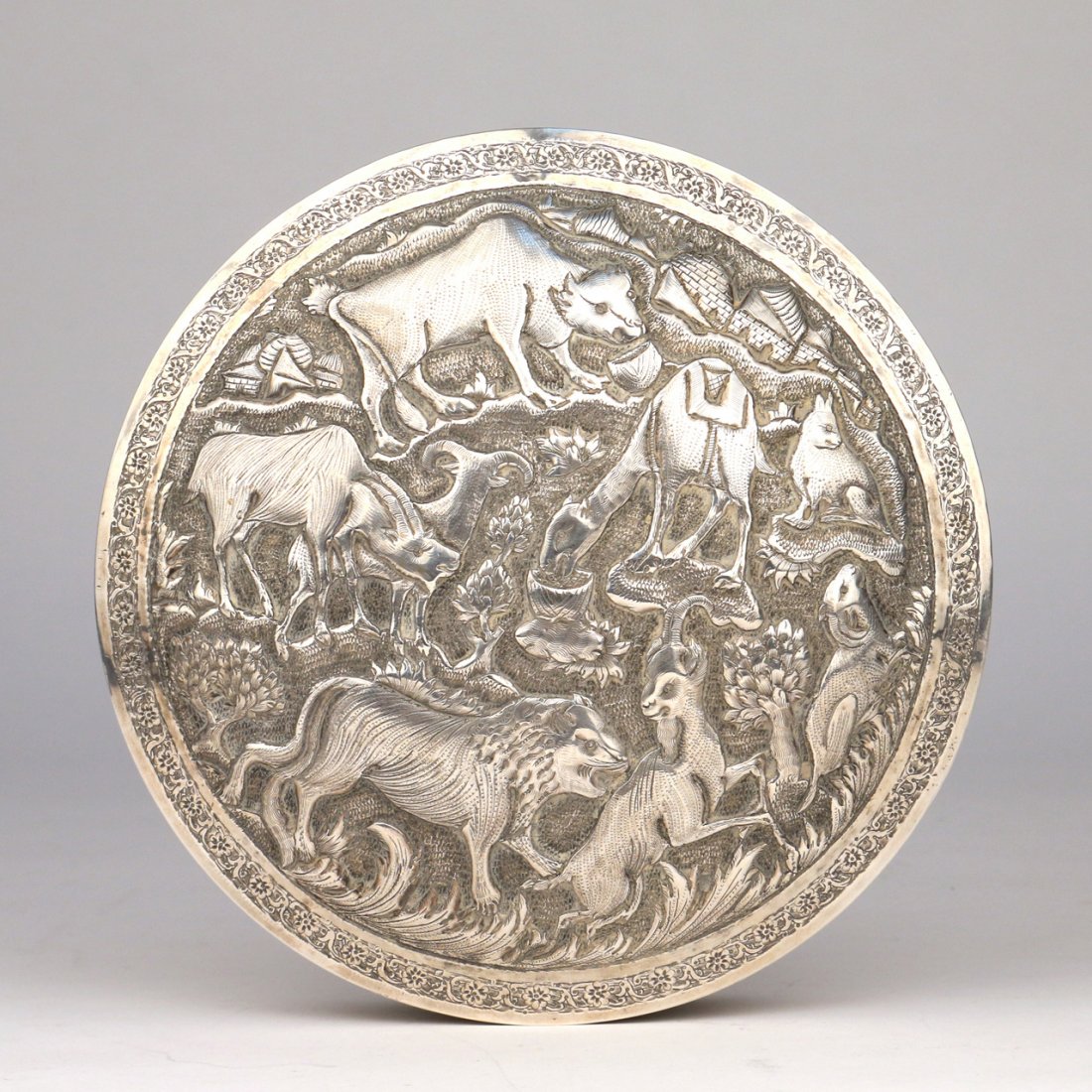 PERSIAN SILVER ROUND LIDDED BOX: Sculptured and incised with animals; dia. 7", h.1 1/2"; appx. 16 toz
