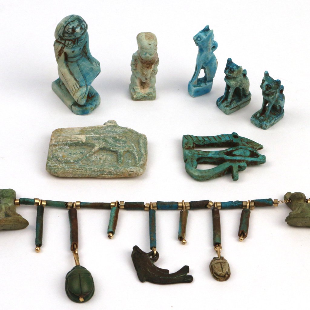 (8pc) EGYPTIAN FAIENCE CARVINGS: including a necklace with six carved cat figures, two scarabs, and a metallic fish, the chain mkd. 14k; a blue mythical figure kneeling, h. 1 3/4 in.; three blue cat pendants; a greenish blue glyph pe