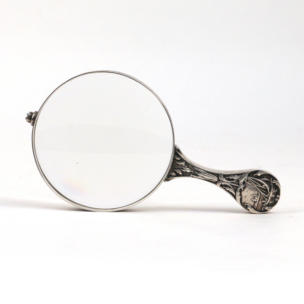 DUTCH SILVER MAGNIFYING GLASS: 19th/early 20th Century, the handle decorated with a sailboat and a windmill in repousse; l. 9 in.; Marked "Holland"