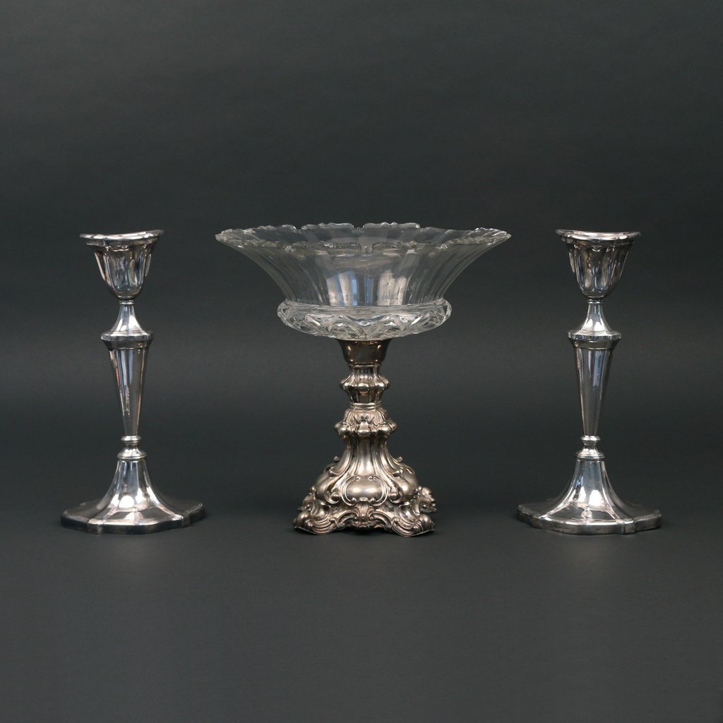 (3pc) LOADED SILVER AND SILVERPLATED HOLLOWARE: including a silver plated Rococo style compote with a glass bowl, cement filled, h. 10 d. 10 1/4 in., mkd. '13' (?); and a pair of loaded silver candlesticks, mark polished off, h. 10 1/2 in.; the com