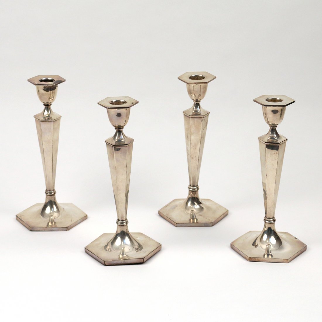 TWO PAIRS WALKER & HALL STERLING CANDLESTICKS: One pair c.1928, one pair c.1930; Pairs appear to have identical pattern and same hallmarks save for the date letters. Hexagonal base with solid wood bottom, likely weighted h. appx 9-1/2in.; one with