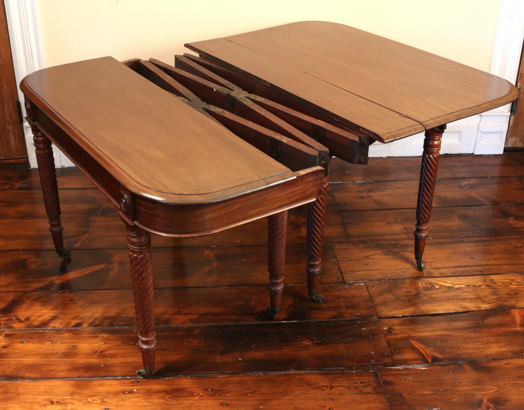 AMERICAN FEDERAL MAHOGANY CONCERTINA-ACTION EXTENSION: DINING TABLE, early 19th Century, with a moulded rectangular flip top above a frieze having roundels at the head of each leg, the ring turned and barley-twist legs ending in peg feet and brass casters
