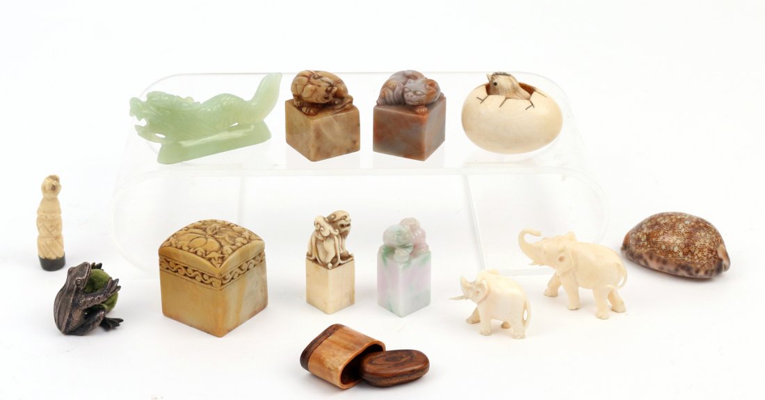 (13pc) GROUP OF MOSTLY CHINESE OBJET D'ART: Including four carved Chinese seals/chops surmounted by foo dogs (one in jade), a soapstone chop with a carved lotus flower, a metal figure of a frog, a horn and wood patch box, a jade (?) carving of 