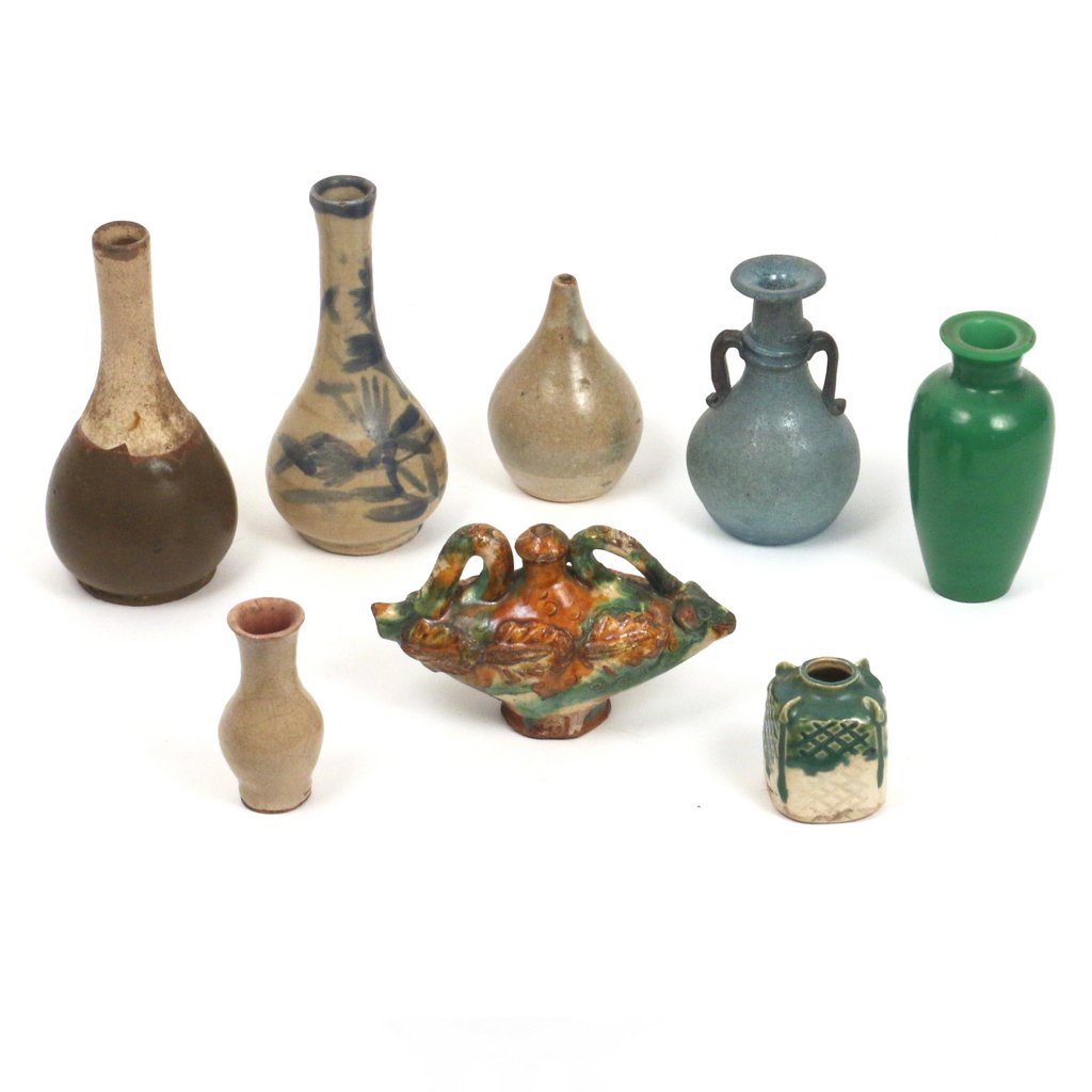 (8pc) CHINESE CERAMIC & OTHER SMALL VASES: including two vases of bottle shape, h. 6 1/4 in.; a green Peking glass vase; a blue Roman style glass vase; two misc. vases in a cream glaze; a Tang style ceramic oil lamp; and a small two-color glaz