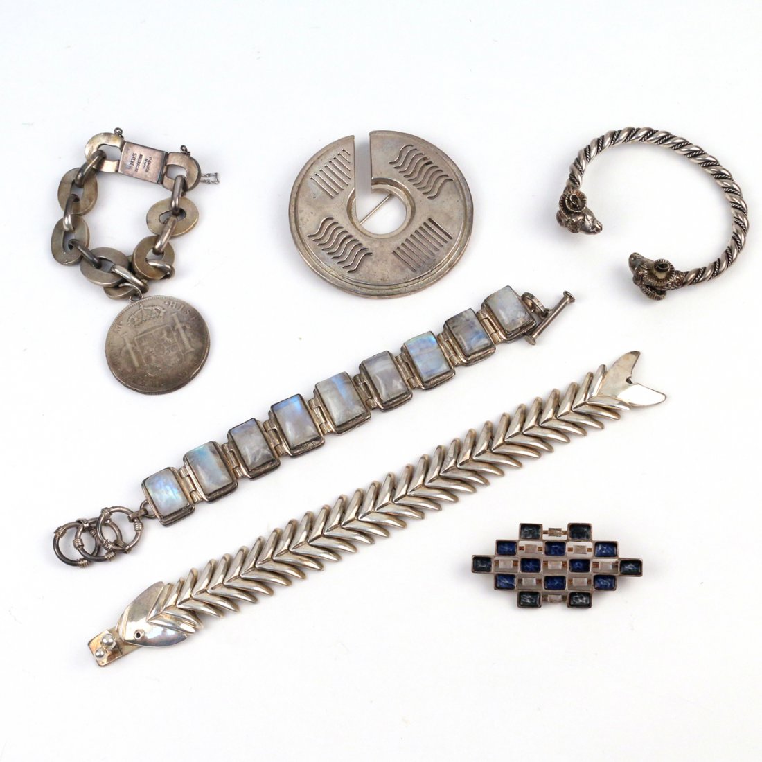 (6pc) MISC. SILVER JEWELRY: including a Los Castillos sterling articulated fish bracelet, 8 in. long; a 'Parra H. Nos' Mexican silver chain link bracelet with a silver dollar charm, no fineness mark (we have not tested the silve