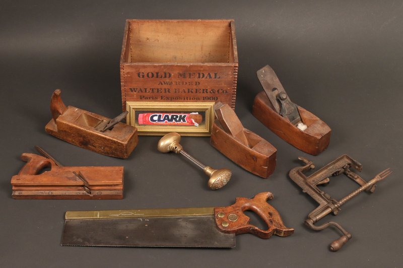 (9pc) ANTIQUE TOOLS: WALTER BAKER & CO. BOX,: WITH APPLE PEELER; DISSTON & SONS BACK SAW W/BRASS BACK; 3-BLOCK PLANES & MOLDING PLANE; BRASS DOOR KNOB ,ENGRAVED PUBLIC SCHOOL; PAINTING OF CLARK CANDY BAR IN TROMPE -L'OEIL STYLE; 2-MINIATURE SAWS 