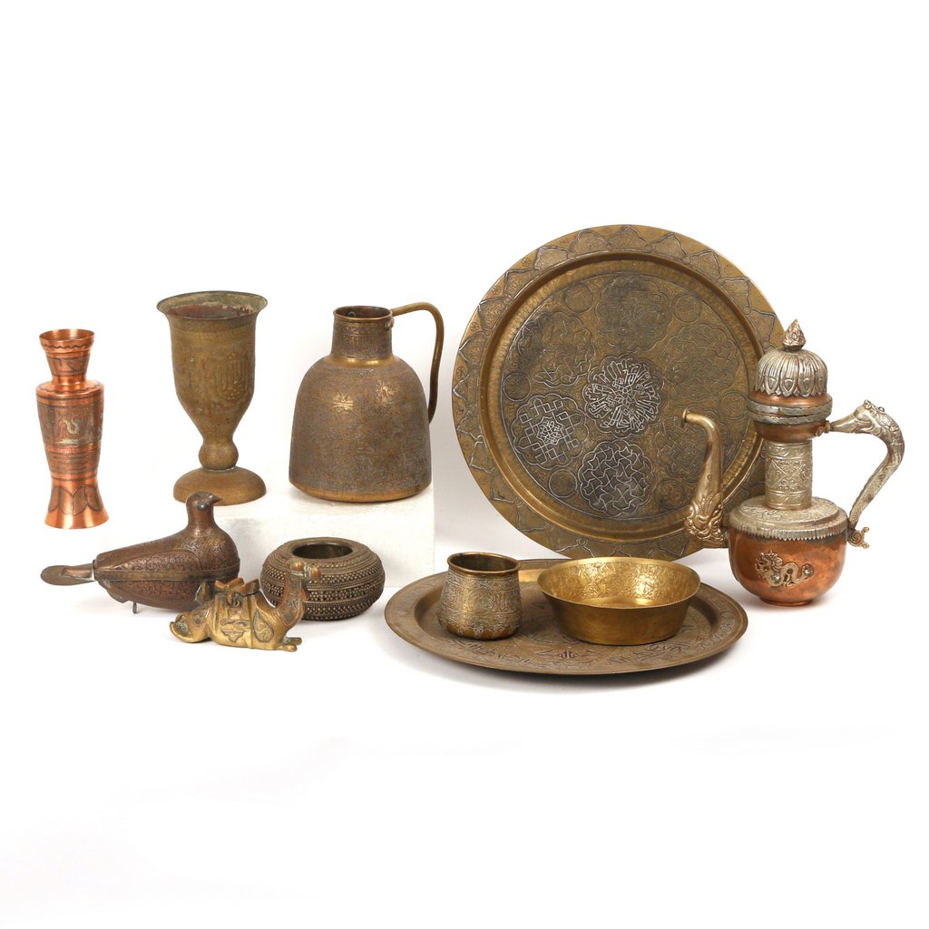 (11pc) MIDDLE EASTERN METALS: Including two similar chargers, d. 14 in.; a bird-form covered vessel; a large footed cup, h. 8 in.; a pitcher; a covered ewer of South-east Asian origin; a copper vase, h. 8 in.; a camel-form inkwell