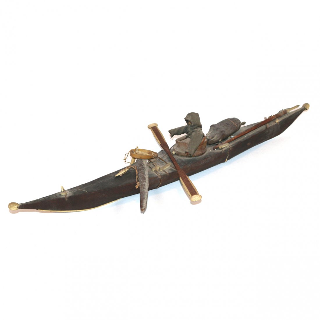 INUIT MODEL OF A KAYAK: INUIT MODEL OF A KAYAKearly 20th Century, carved wood with fabric and leather, with several accessories, 23 in. long