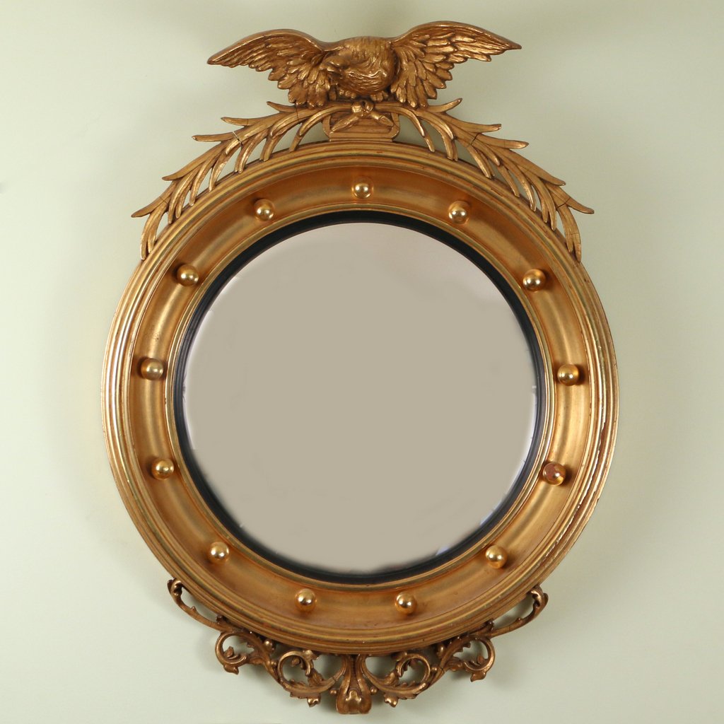 REGENCY STYLE GILT CONVEX MIRROR: REGENCY STYLE GILT CONVEX MIRRORearly 20th Century, crested by an eagle clutching laurel leaves, 30 x 22 in.