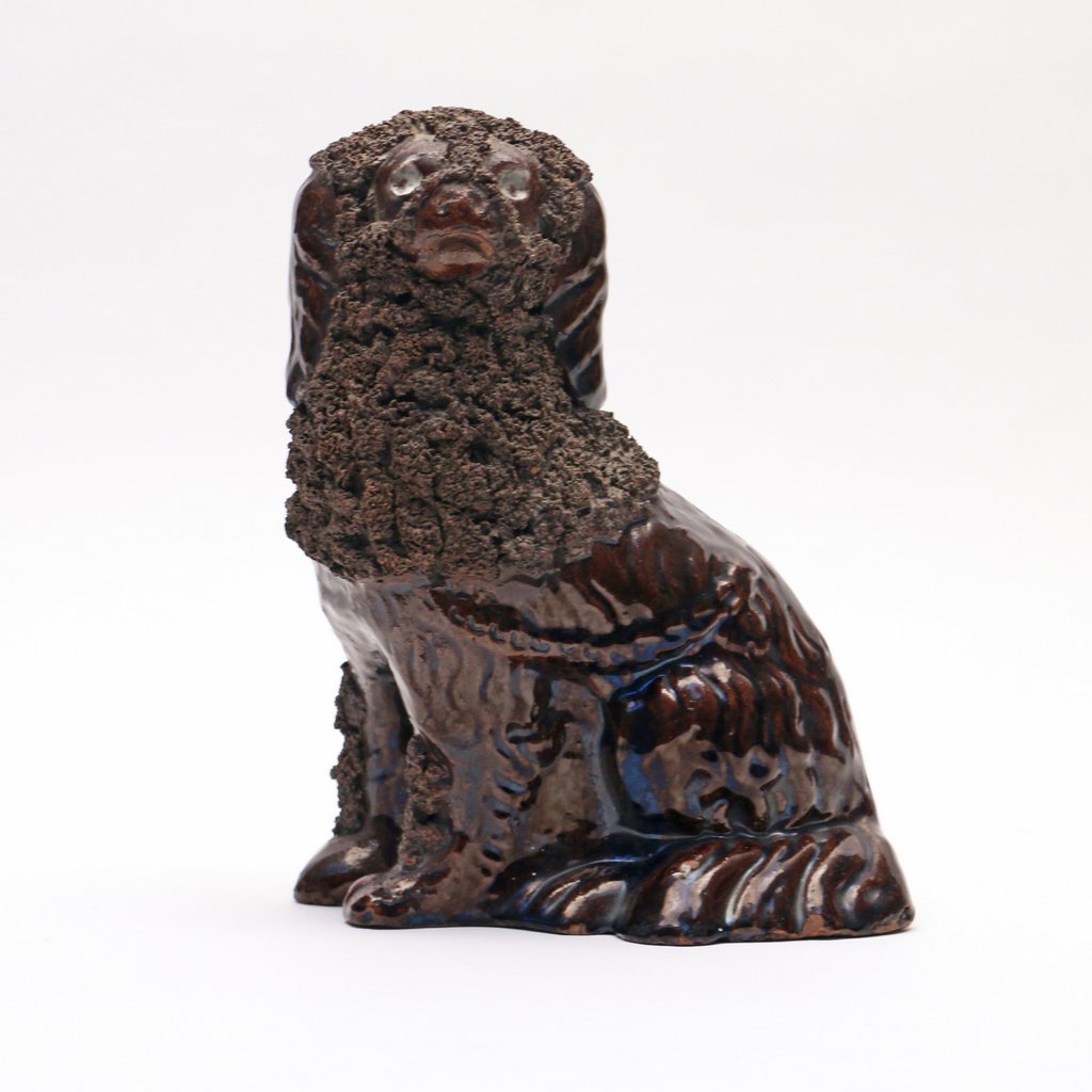 19TH C. FORK ART EARTHENWARE SPANIEL: 19TH C. FORK ART EARTHENWARE SPANIELseated in an upright position and with a 'coleslaw' mane, dark brown glazed earthenware, h. 8-3/4 in.cond.: