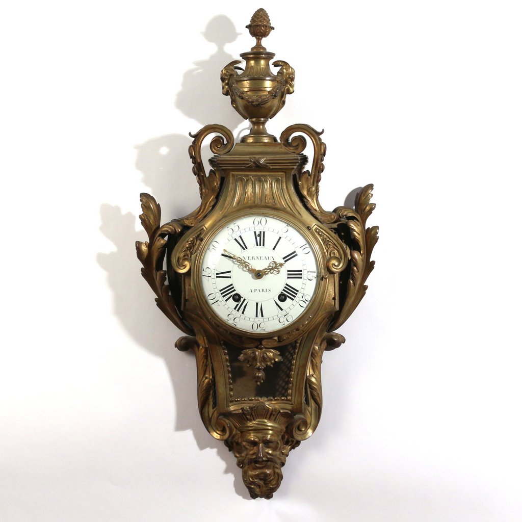 LATE LOUIS XV ORMOLU CARTEL CLOCK: by François Verneaux, Paris, circa 1775, having ram's-head urn-form finial above a shaped case with acanthus scrolls terminating in a mask of Chronos, the white dial signed "VERNEAUX / A PARIS", h. 3