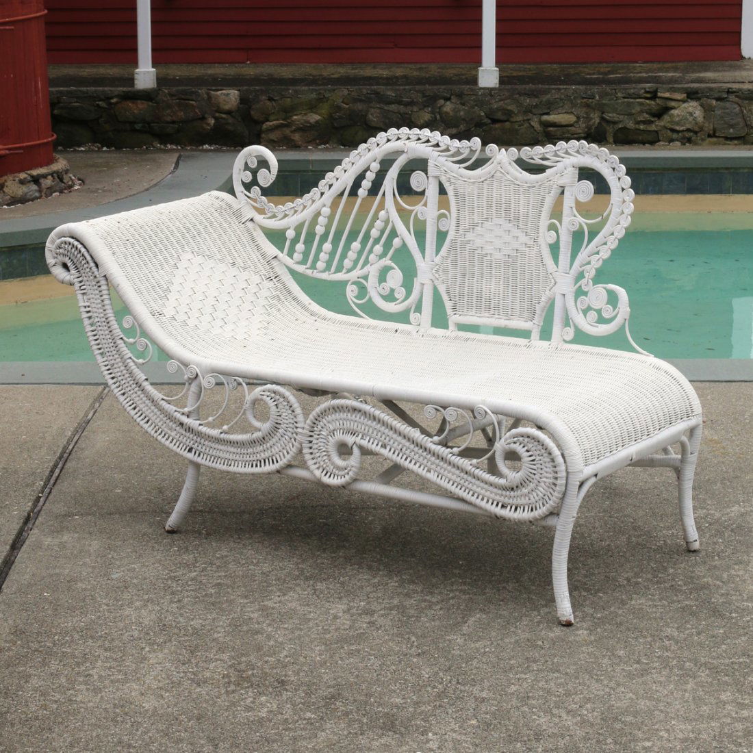 WICKER CHAISE LOUNGE: early 20th Century, with an elaborate scrollwork backrest, h. 37-1/2 w. 63 d. 24 in.