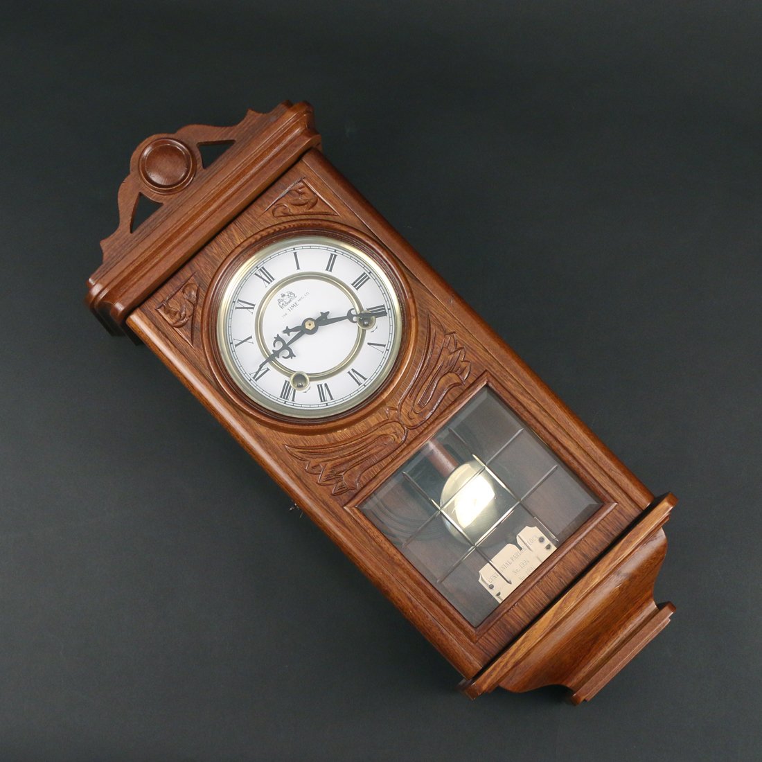 OAK CENTENNIAL PARLOUR CLOCK: A hanging wall clock by Time Manufacturing Co. 20th c. h.21w. 8-1/2 d.4-1/2 in.