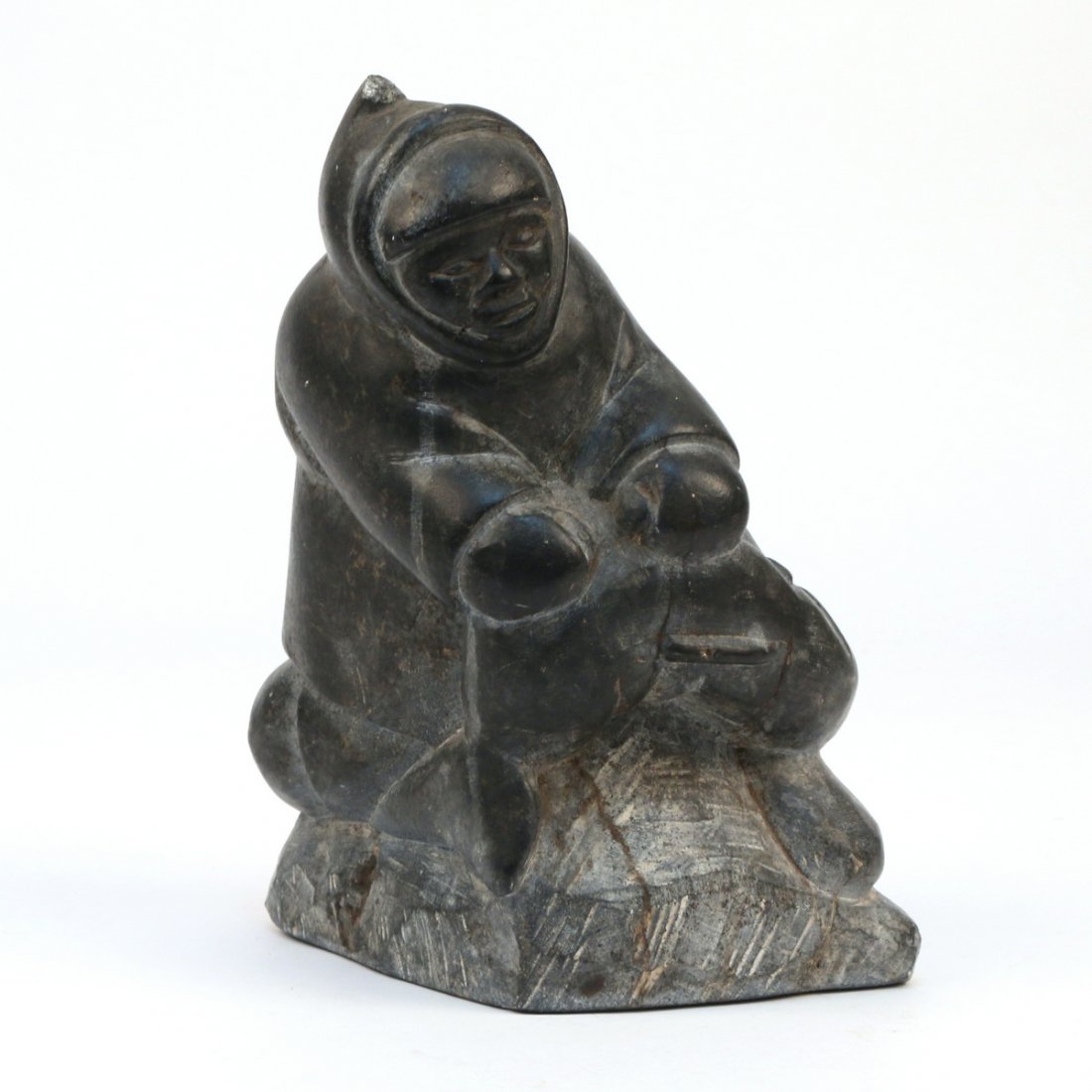 INUIT SOAPSTONE CARVING: Depicting a fisherman crouching with a catch over his knees, signed/ marked on bottom; h. 9 in.