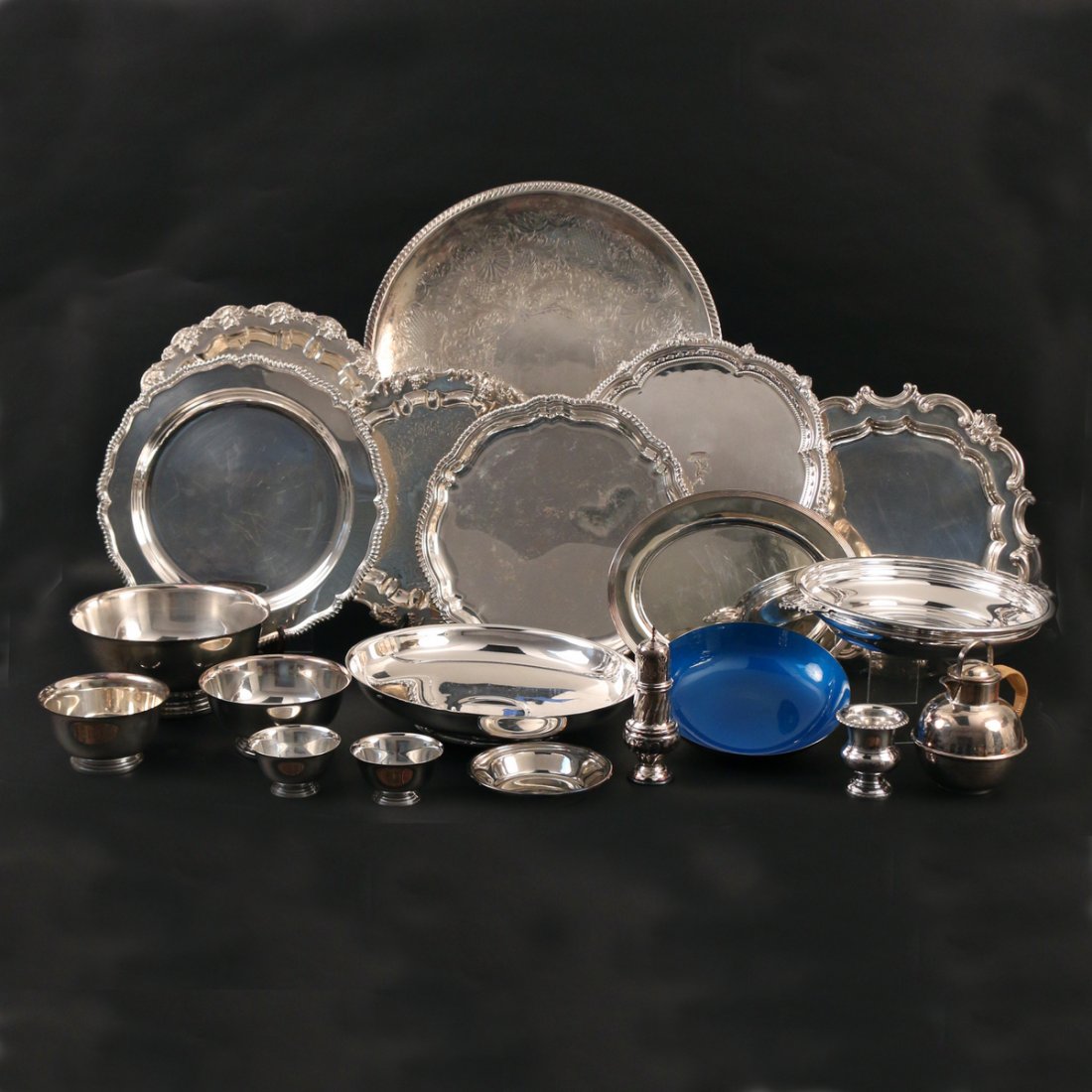 (20pc) MISC. SILVER-PLATED HOLLOWARE: including 7 round trays (17-3/4 in., largest), 1 oval tray, 5 revere-style bowls, 1 enamel bowl, 2 large shallow bowls, 1 wine coaster, 1 cigarette urn, 1 sugar caster, and 1 teapot