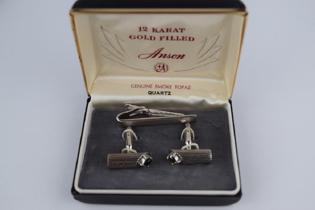 12K GOLD FILLED ANSON CUFF LINKS & TIE CLIP: Elegant Anson 12K gold filled set. Cufflinks with smokey topaz cabochons and tie clip with quartz round cut stone. Cufflinks 7/8" L, Clip 1 3/4" L. Included in a Anson fitted presentation box. Total w