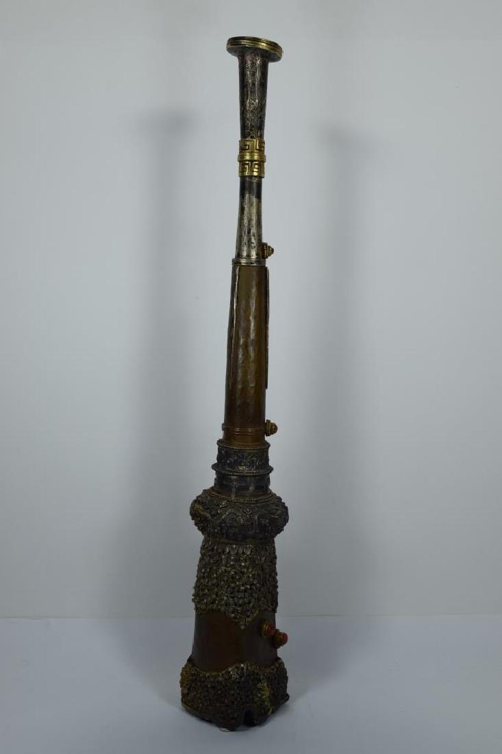 NEPALESE BUDDHIST MONK PRAYER CEREMONIAL HORN: Copper and brass prayer horn. Hand etched flying dragons, dragon faces, symbols and floral motif throughout. Measures 22 1/2" L x 4" W x 3 1/4" D. Weighs 2lbs., 8oz. THIRD PARTY SHIPPING REQUIRED.