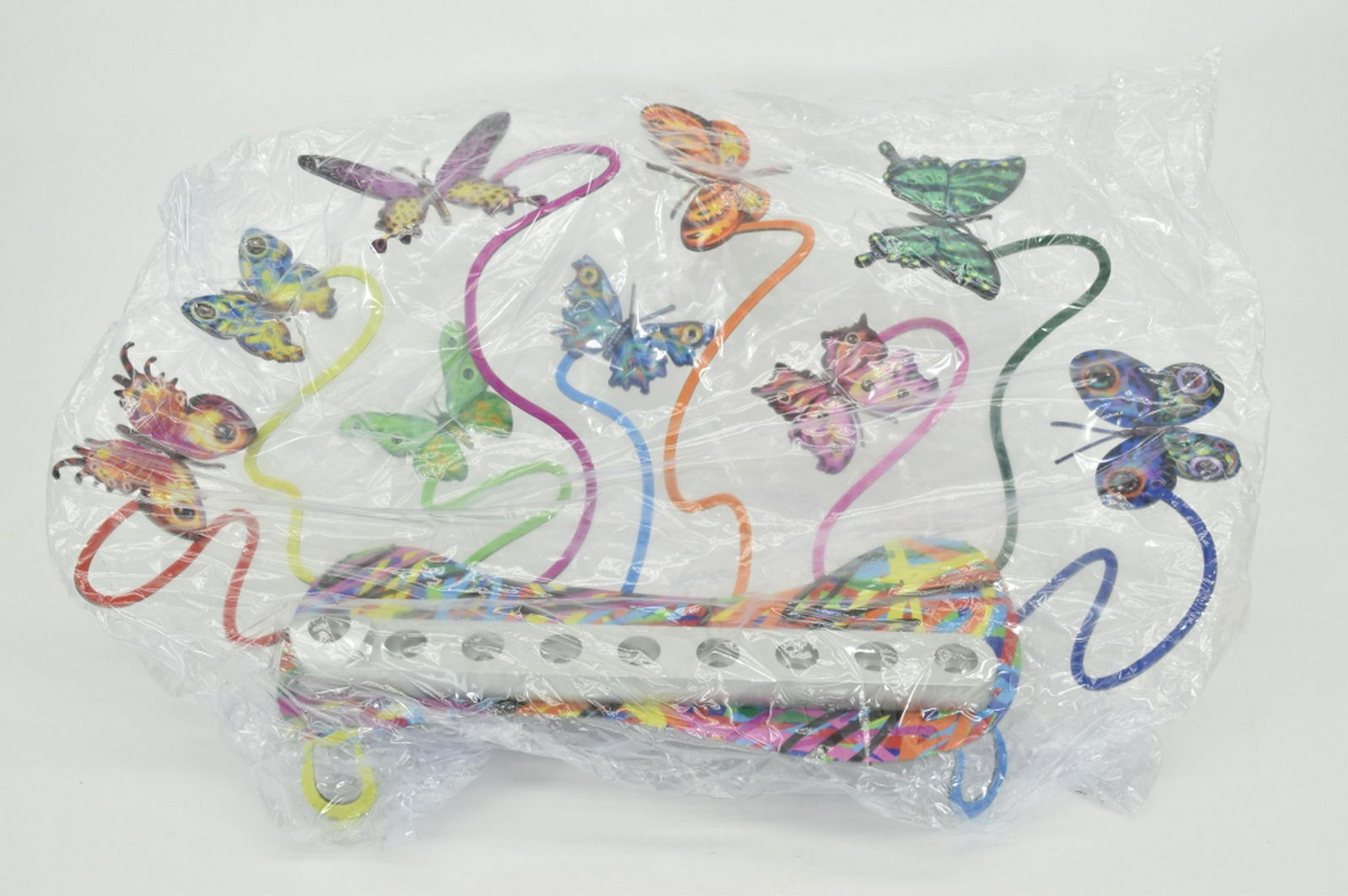 DAVID GERSTEIN COLORFUL METAL BUTTERFLIES MENORAH: Nine swirled stems in a variety of colors, with intricately designed butterflies perched on top of the candle holders. David Gerstein, who lives and works in Jerusalem, has widely exhibited in museums
