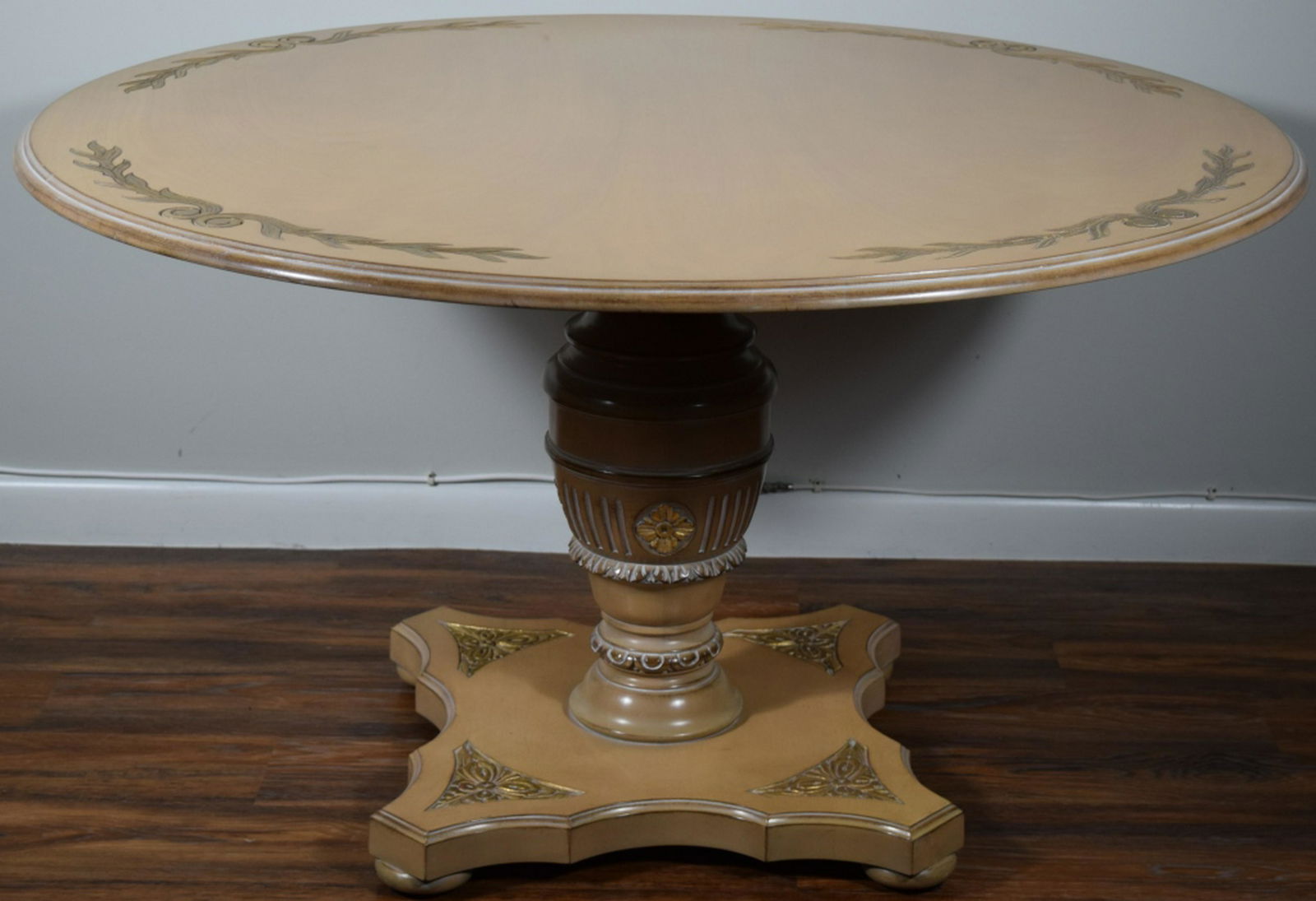 VINTAGE LARGE ROUND WOODEN TABLE: Traditional round table with light colored wood, hand carved floral scrollwork with gold leaf, matching vase-shaped column and square base. Tabletop measures 44" in diameter, base measures 20" W. THIR