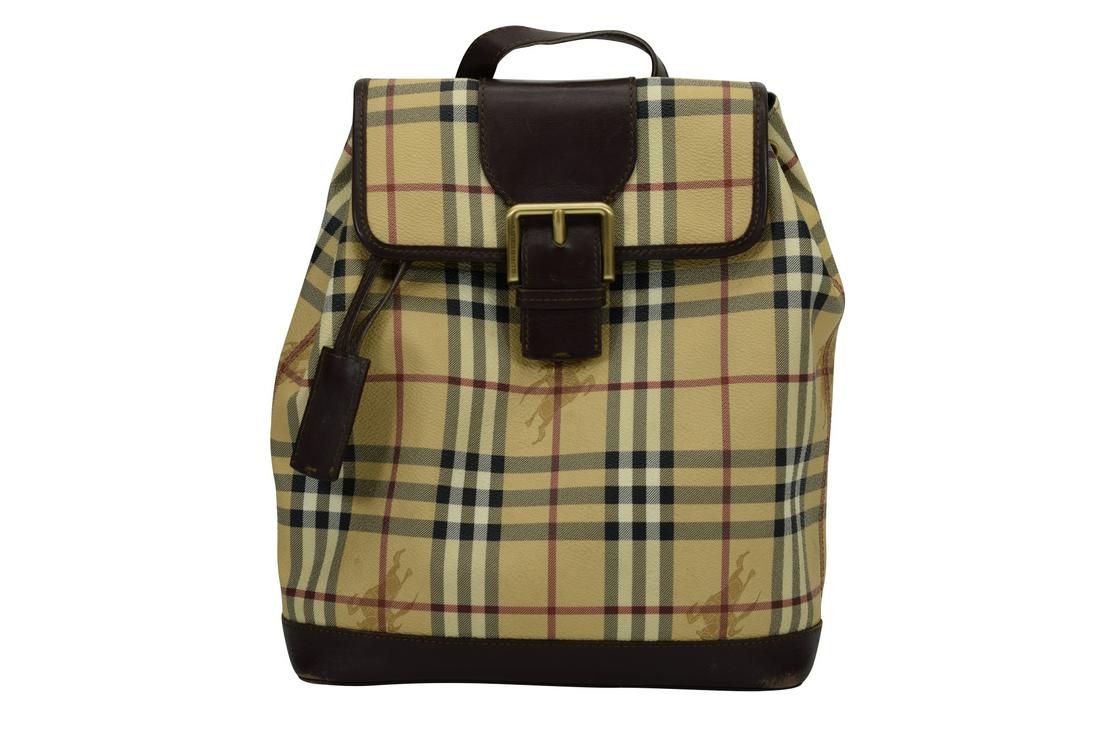 BURBERRY HAYMARKET LEATHER BACKPACK BAG: Burberry London made in Italy, main compartment having a zipper pouch to one side and 2 phone or notes pockets on the other side. Measures 12-1/2" H x 10-3/8" W x 3-3/4" D. Coming in dust bag. U.S. SH