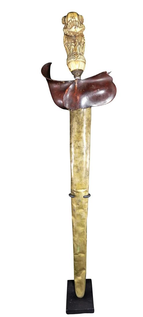 ANTIQUE WHALE TOOTH MADURA KRIS: Antique Whale Tooth Madura Kris, Damascus Steel, Carved Wooden Handle Shield, Ivory Carved Handle, Ornately Carved Ivory Handle Measures 19 3/4" x 5". Weighs 6lbs. This item is not available for inter