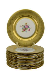 12PCS 22 KARAT GOLD FLORAL PORCELAIN DINNER PLATES: Twelve porcelain 22k gold plates having a flower arrangement to the centers. Holds unknown maker's hallmark stamp bottom, a crest with two lions and the letter "A", and "Warranted 22k gold. Each