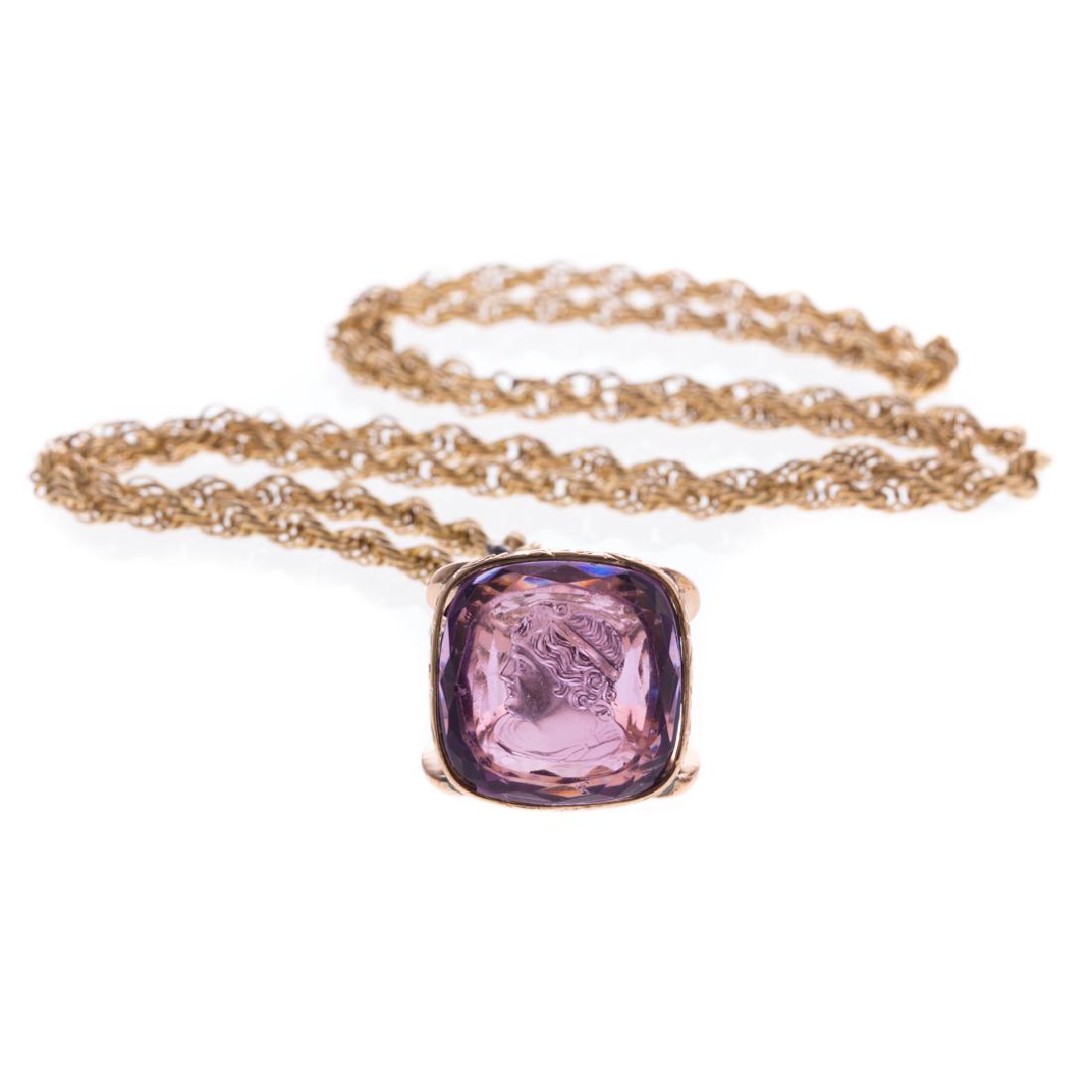 An Amethyst Intaglio Watch Fob and Chain: 14K yellow gold amethyst intaglio watch fob on gold plated rope chain, 24 in. L, 26 grams
