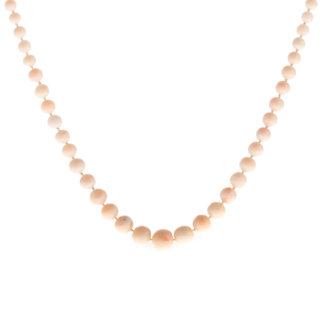 A Lady's Angel Skin Coral Necklace: 14K yellow gold closure featuring a carnelian on the box clasp attached to a graduated strand of coral beads ranging in sizes 5.40mm-12.30mm, 22 in. L