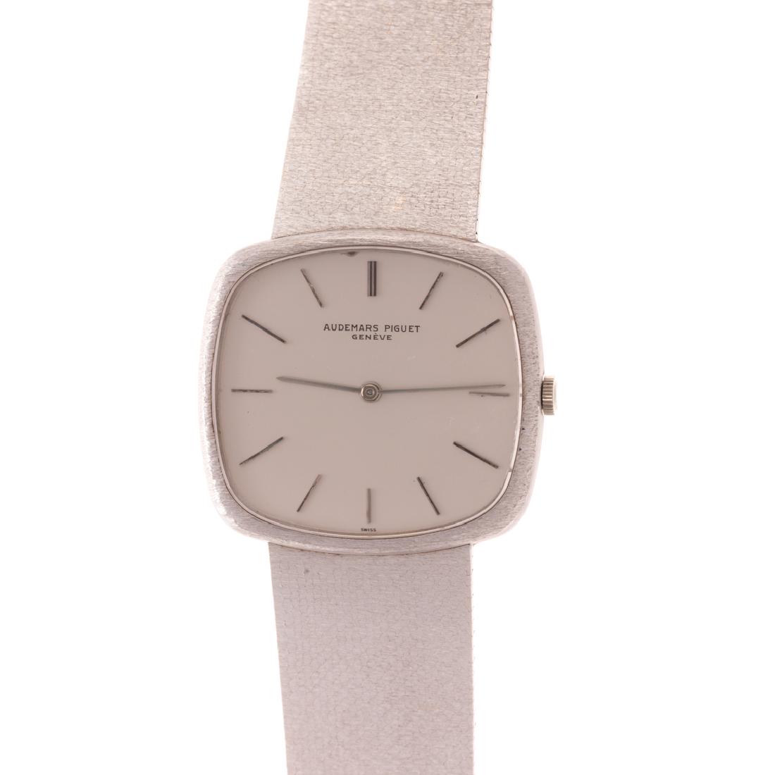 A Gent's 18K Audemars Piguet Wrist Watch: 18K white gold Audemars Piguet wrist watch, silver colored cushion shape face, dashes for numbers, mesh bracelet with fold over clasp, Serial #82563, 94.4 grams