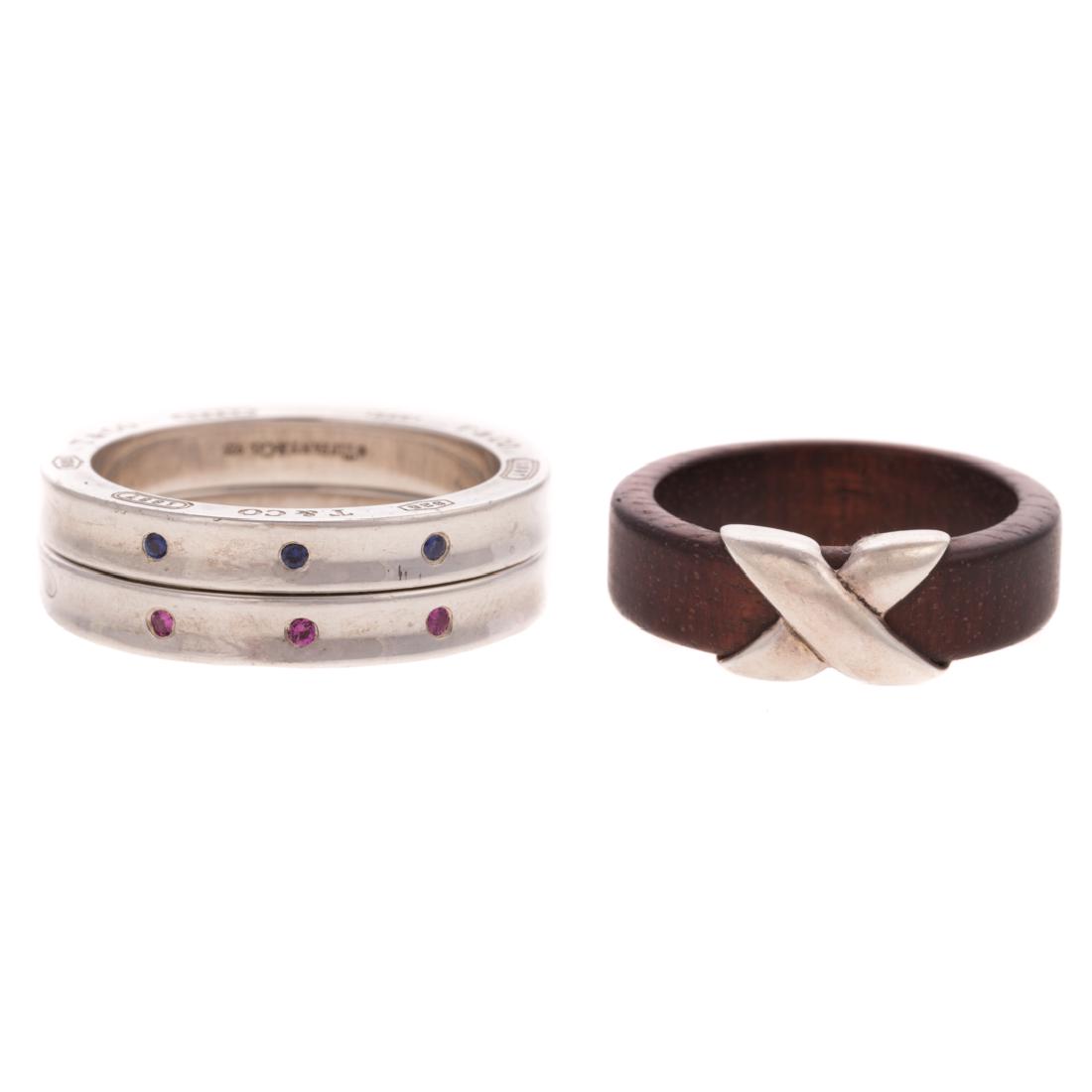 A Trio of Silver Stackable Rings by Tiffany & Co: 1) Sterling silver "Signature "X" ring by Tiffany & Co, made in Italy, featuring wide wooden band with high polished "X" in the center, sz 8, 2) Pair of sterling silver bands from the 1837 collection,