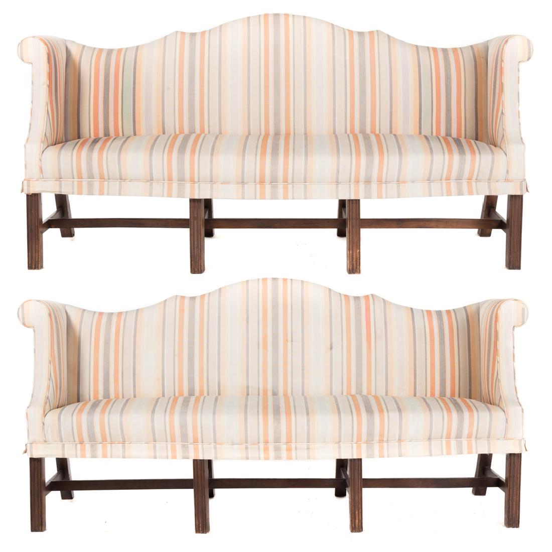 Pair George III style mahogany upholstered settees: 20th century; serpentine upholstered backs, upholstered arms and seats, square fluted legs connected by stretchers, 39 1/2 in. H., 81 in. W., 24 1/2 in. D.; From the Estate of Harry C. Meyerhoff