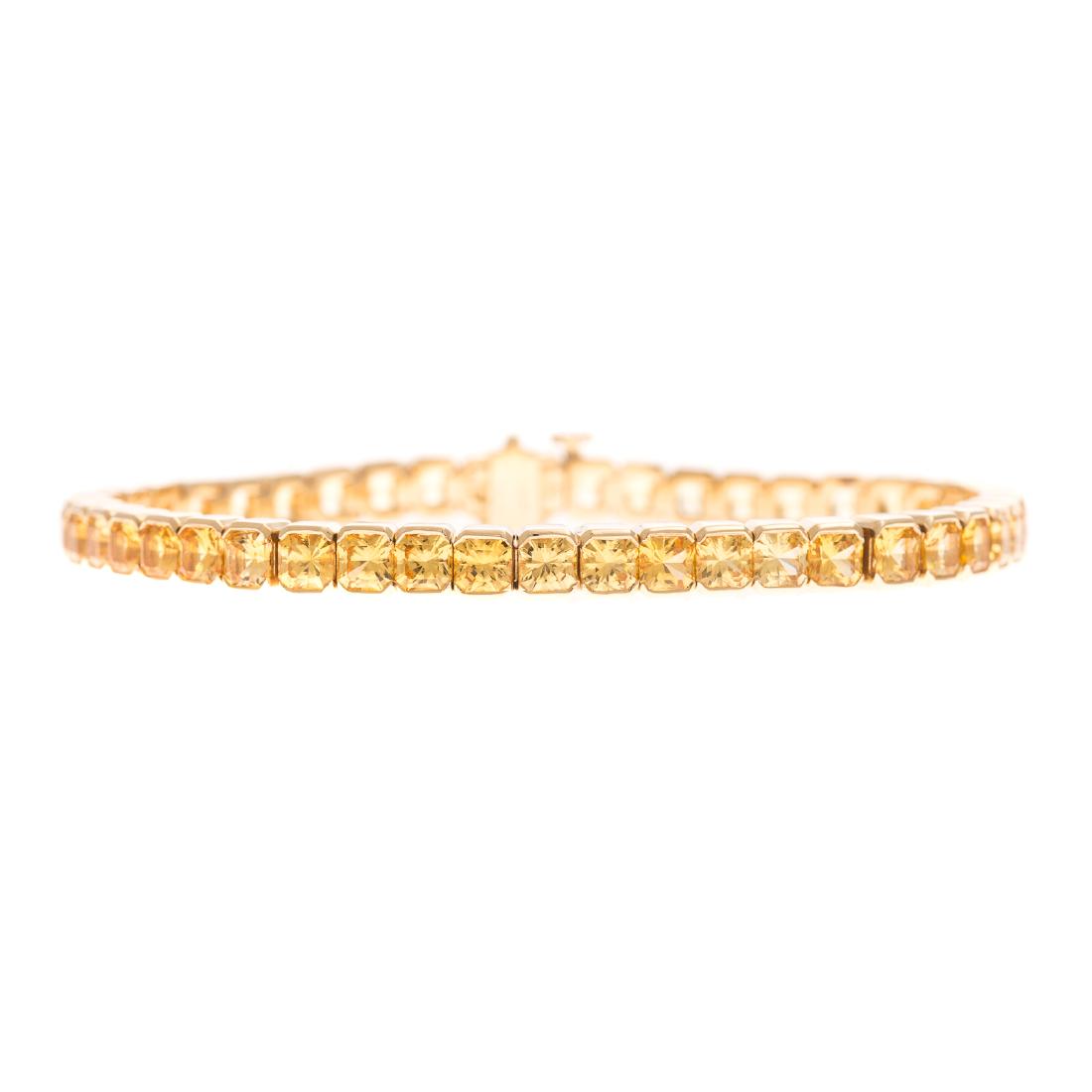 An Important Yellow Sapphire Line Bracelet in 18K: 18K yellow gold bracelet featuring 45 well matched radiant cut weighing 16.79 carats set in semi bezels, hidden box clasp with snap under safety, 7.25 in. L, 31.2 grams