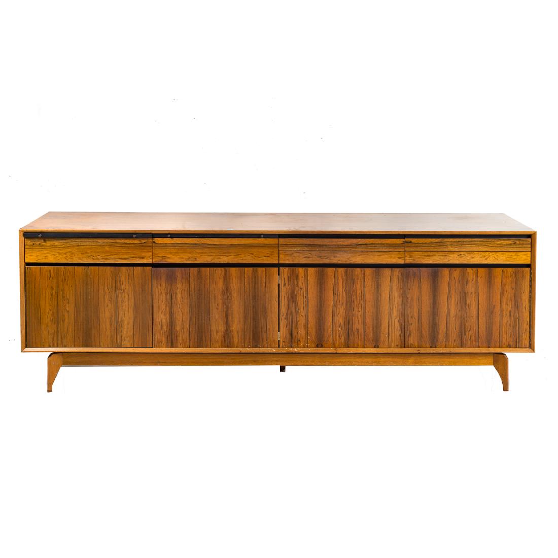 Cabinet-made Mid-Century Modern teakwood credenza: early 1960s; rectangular case, fitted with six slender drawers and two sliding serving panels, over compartments enclosed by four solid paneled doors, tapered feet, 31 1/2 in. H, 93 in. L, 19 3/4 in. 