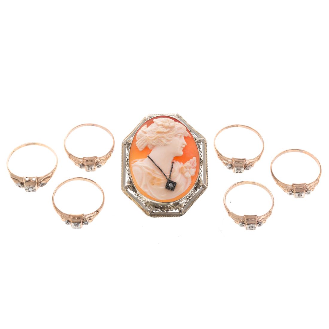 A Collection of Gold Rings & a Cameo Pin: 1)Six matching 10K yellow gold rings, each featuring a small native cut diamond in the center, 6 grams tw, and 2)14K white gold hand carved shell cameo pin/pendant with filigree frame, 1.75 in. L, 12.
