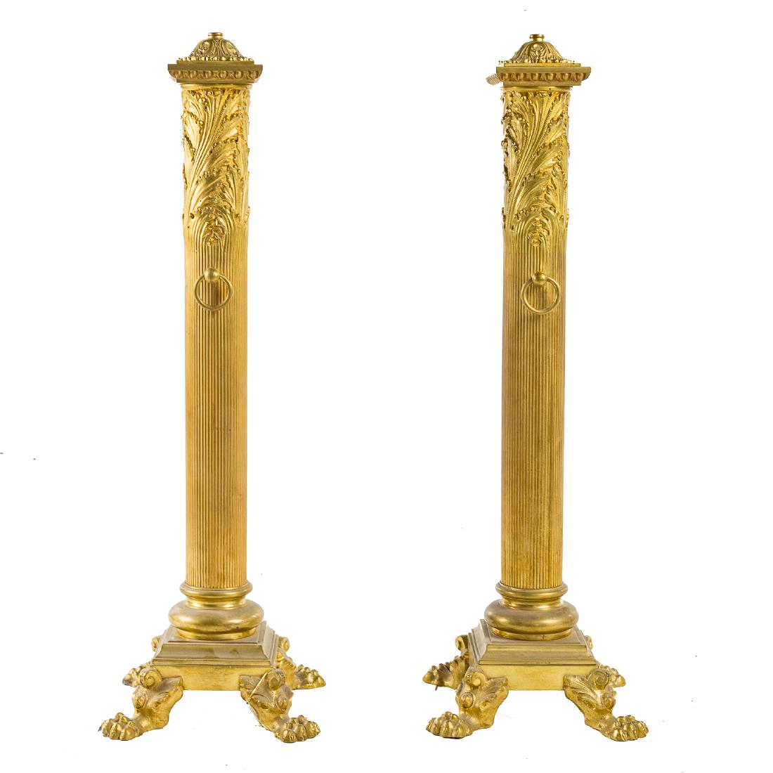 Pair Classical style brass andirons: early 20th century; foliate caps, egg and dart capitals, fluted and foliate columns, molded step base, four brass paw feet, 31 3/4 in. H., 10 3/8 in. W., 10 3/8 in. D.