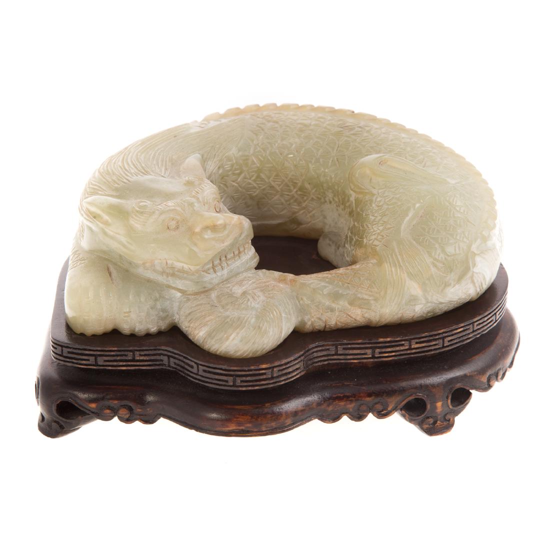 Chinese carved jade sleeping dragon: detailed rendition of slumbering mythical beast, 5 in. W., with carved wood stand; Estate of Dr. William M. King, Fort Lauderdale, FL.
