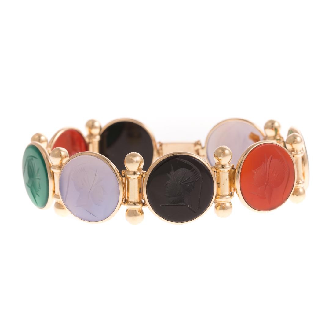 A Ladies Intaglio Bracelet in 14K Gold: 14K yellow gold bracelet, comprised of 8 bezel set intaglios including: black onyx, carnelian, malachite, and hardstone, alternating with bar links, box clasp, safety latch, 8 in. L, 23.9 grams tw