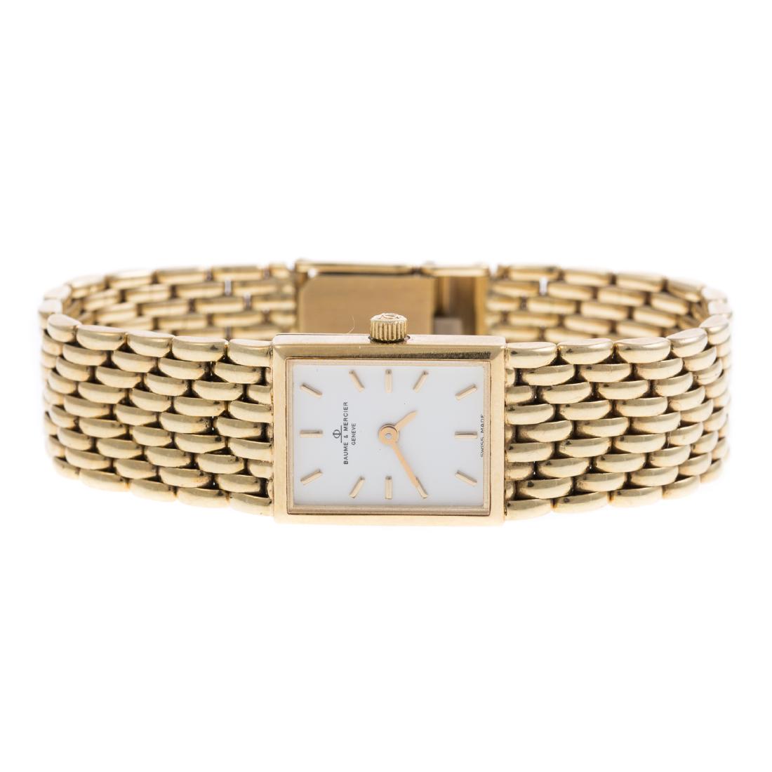 A Ladies Baume & Mercier Dress Watch in 14K Gold: 14K yellow gold watch, Swiss, model # 5744T and serial # 2114774, with a sleek braided strap, rectangular dial, stick numerals, fold over clasp, additional links, 6.25 in. L, 36.4 grams tw