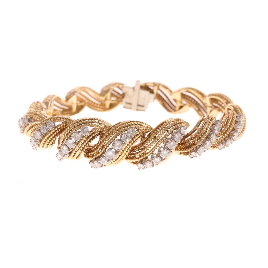 A Ladies Diamond San Marco Bracelet in 18K: 18K yellow gold textured San Marco bracelet, graduated design featuring 45 well matched very fine full cut diamonds weighing approx. 3.00 ctw set in the top links, hidden box clasp with snap under saf