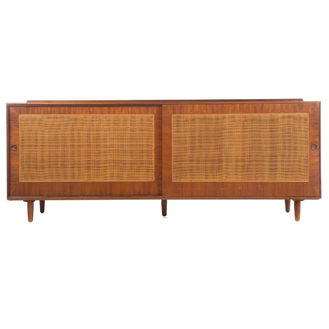 Finn Juhl for Baker Mid-Century Walnut Credenza: circa 1950; caned paneled sliding doors, interior with three drawers and shelf, 31 in. H., 78 in. W., 18 in. D.