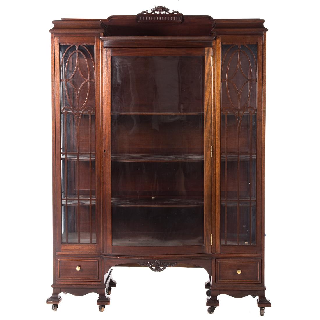 Edwardian Mahogany China Cupboard: 20th century, raised splashboard with carved basket of fruit, compartment with shelves enclosed by filigreed glass panel sides and bow-front glass door, two short drawers beneath; 72 in. H., 48 3/4 in