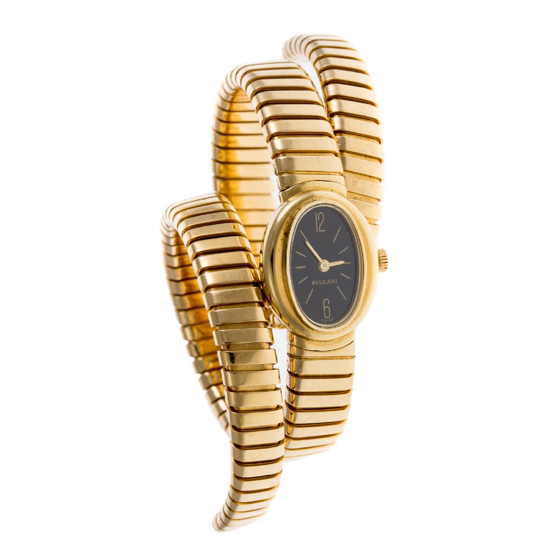 A Ladies 18K Bulgari Serpentini Wrap Watch: 18K yellow gold Serpentini wrap watch by Bulgari, oval black face, with flexible 18K yellow gold double sides bracelet, model #G.1211.4 and serial #7801, 87.2 grams