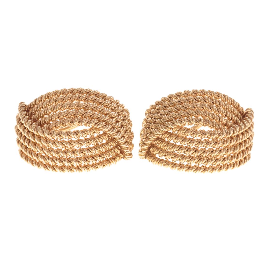 A Ladies Pair of 14K Earrings by Tiffany & Co.: 14K yellow gold earrings in a classic design consisting of 10 rows of textured rope in a half hoop style, post lever back, signed Tiffany & Co., offered with pouch, 1 in. L, 14.3 grams