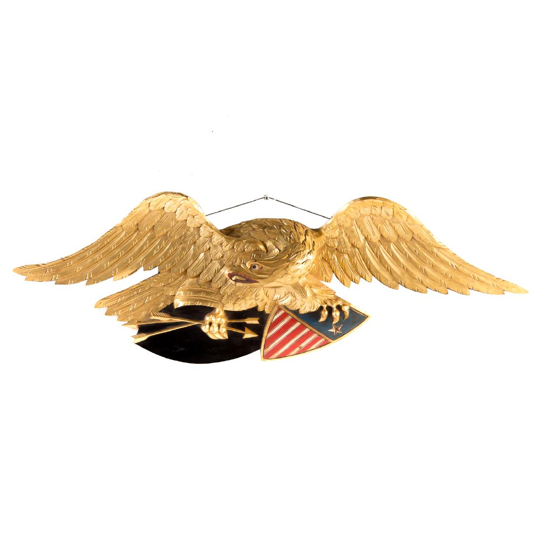 American Painted and Gilt Wood Eagle: 20th century; exquisitely carved and gilt eagle on polychromed United States shield, highly detailed, in the manner of John Bellamy, 14 1/2 in. H., 45 in. L.