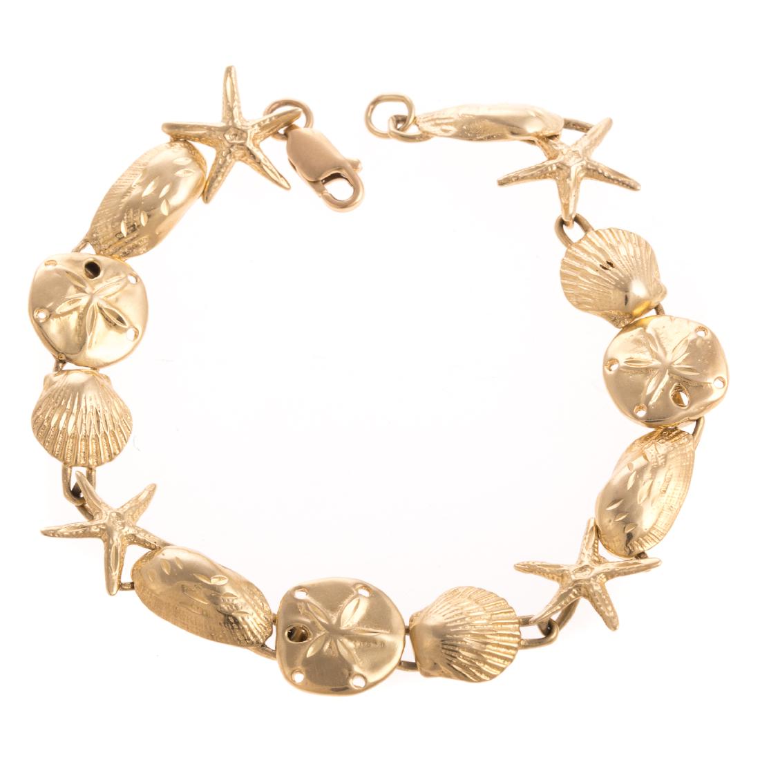 A Ladies Starfish & Seashell Bracelet in 14K Gold: 14K yellow gold bracelet featuring star fish, sand dollars, seashells, and oysters alternating in a classic straight line design, lobster clasp, 6.75 in. L, 13 grams