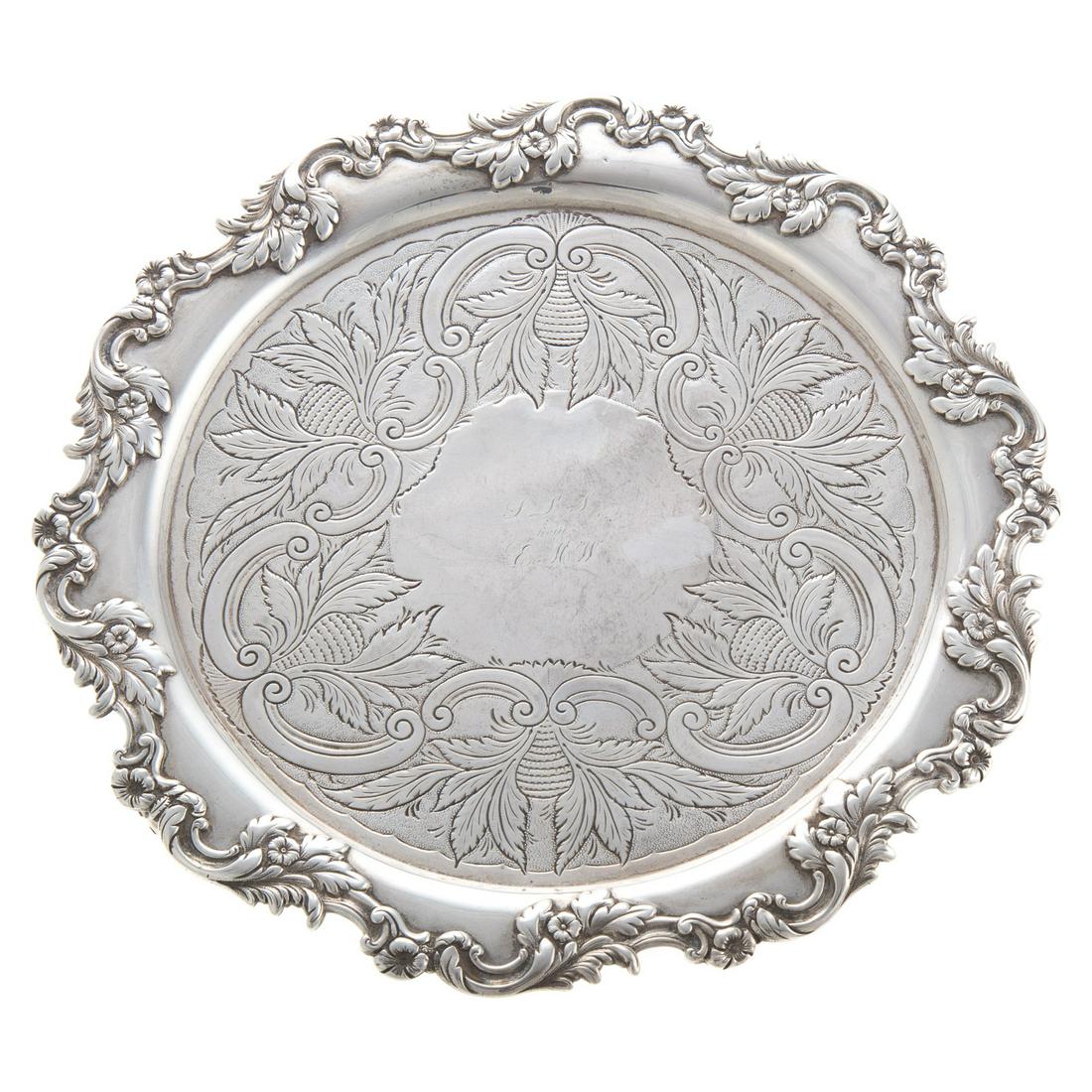 A E Warner Coin Silver Salver: Baltimore, c1870, hand engraved foliate and c-scroll center with initial reserve panel, floral and scroll border, standing on 3 claw feet, 9 in. Diam., 18.65 ozt. From a private Baltimore collection.
