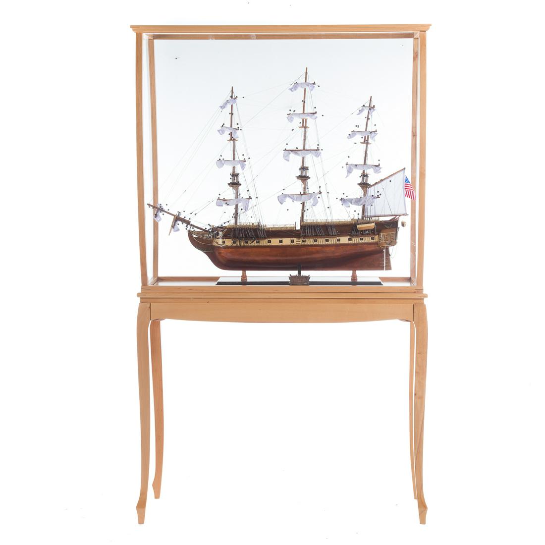 U.S.S. Constitution Wood Model And Display Stand: detailed wood model of legendary United States warship, with elaborate rigging, 31 in. H., 36 in. L. with wood and plexi glass display stand, 68 in. H., 40 in. W., 13 in. D.