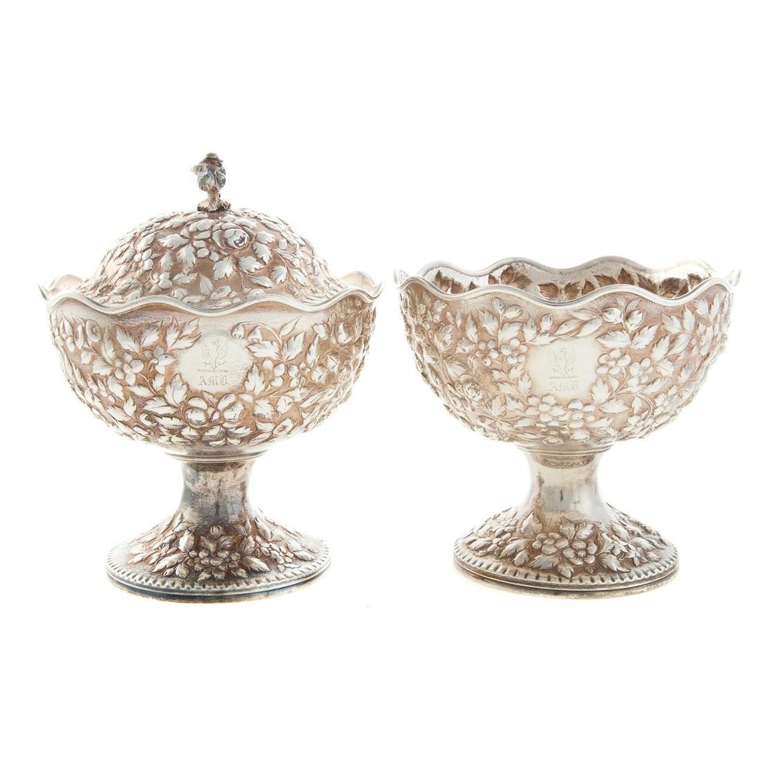 Two A. E. Warner Sterling Silver Pedestal Dishes: Mid-19th century, Baltimore, 11-2 sterling mark, each with floral repousse decoration, and armorial crest with "AMB" monogram, one with cover, 5.75 in to 8 in. H, 32.4 ozt.
