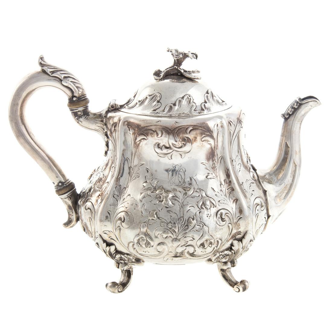 Victorian Silver Foliate Repousse Teapot: John Samuel Hunt, London, 1857, full bulbous form, with allover foliate repousse decoration, foliate-capped handle and spout, the hinged cover with floral finial, with small chased monogram, 7 1/4 in.